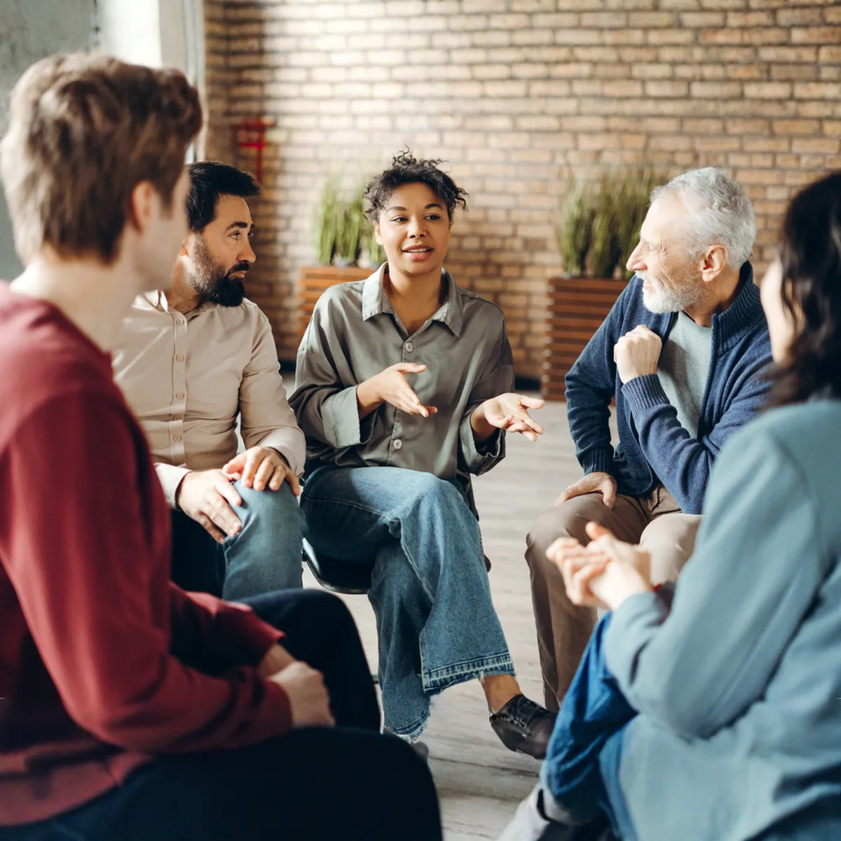A small group sitting in a circle, mid-conversation