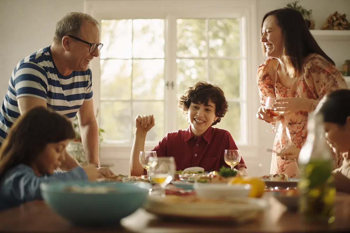 Friends and family laughing around a dinner table at home